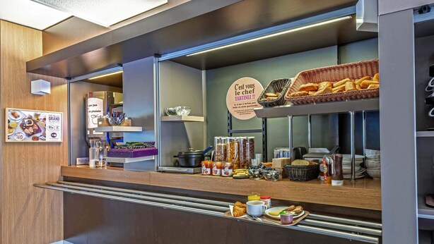 Een bakkerij toonbank met gebak, brood en toevoegingen.