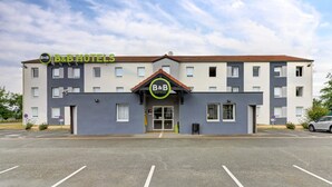 Un hôtel-restaurant de type « bed and breakfast » doté d’une façade moderne, d’une entrée centrale et d’un parking situé devant l’établissement.