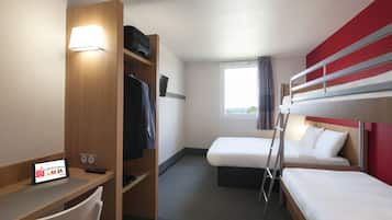 Habitación de hotel con escritorio, dos camas, armario y ventana con cortinas.
