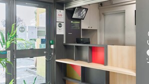Een receptie met een bureau, planken en een deur.