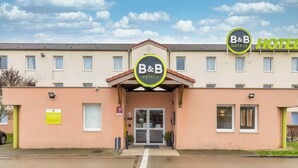Un hotel B&B con una fachada sencilla, una entrada central y un cielo despejado.