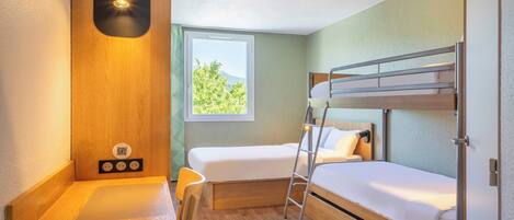 Une pièce de taille modeste, comprenant un lit superposé, un bureau avec une chaise, une fenêtre donnant sur un paysage agréable et un luminaire fixé au mur.