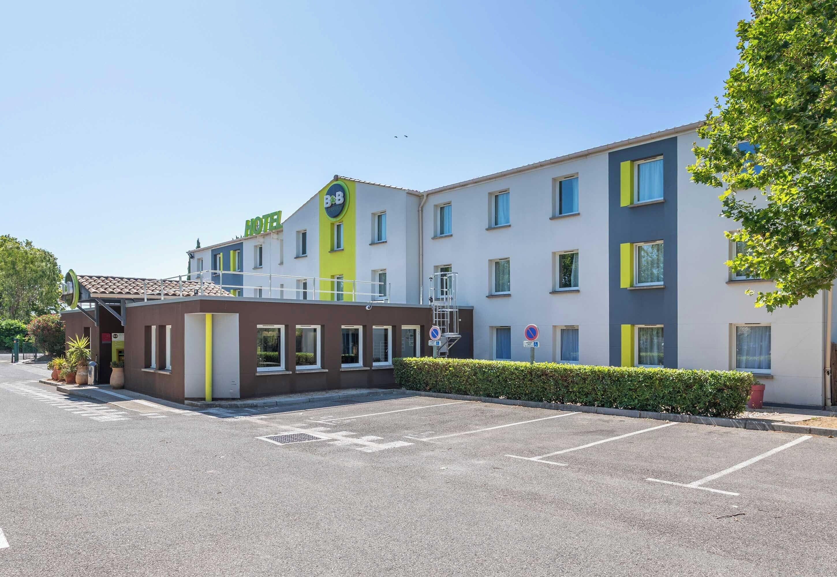 Un hôtel au design moderne, doté d’un parking et offrant une vue sur un ciel dégagé.