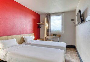 A hotel room with two beds, a desk, a chair, a TV mounted on the wall, and a window with curtains. - B&B HOTEL Clermont-Ferrand Gerzat 1 (Gerzat)