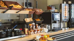 A breakfast buffet with various food items, a coffee machine, and a toaster.