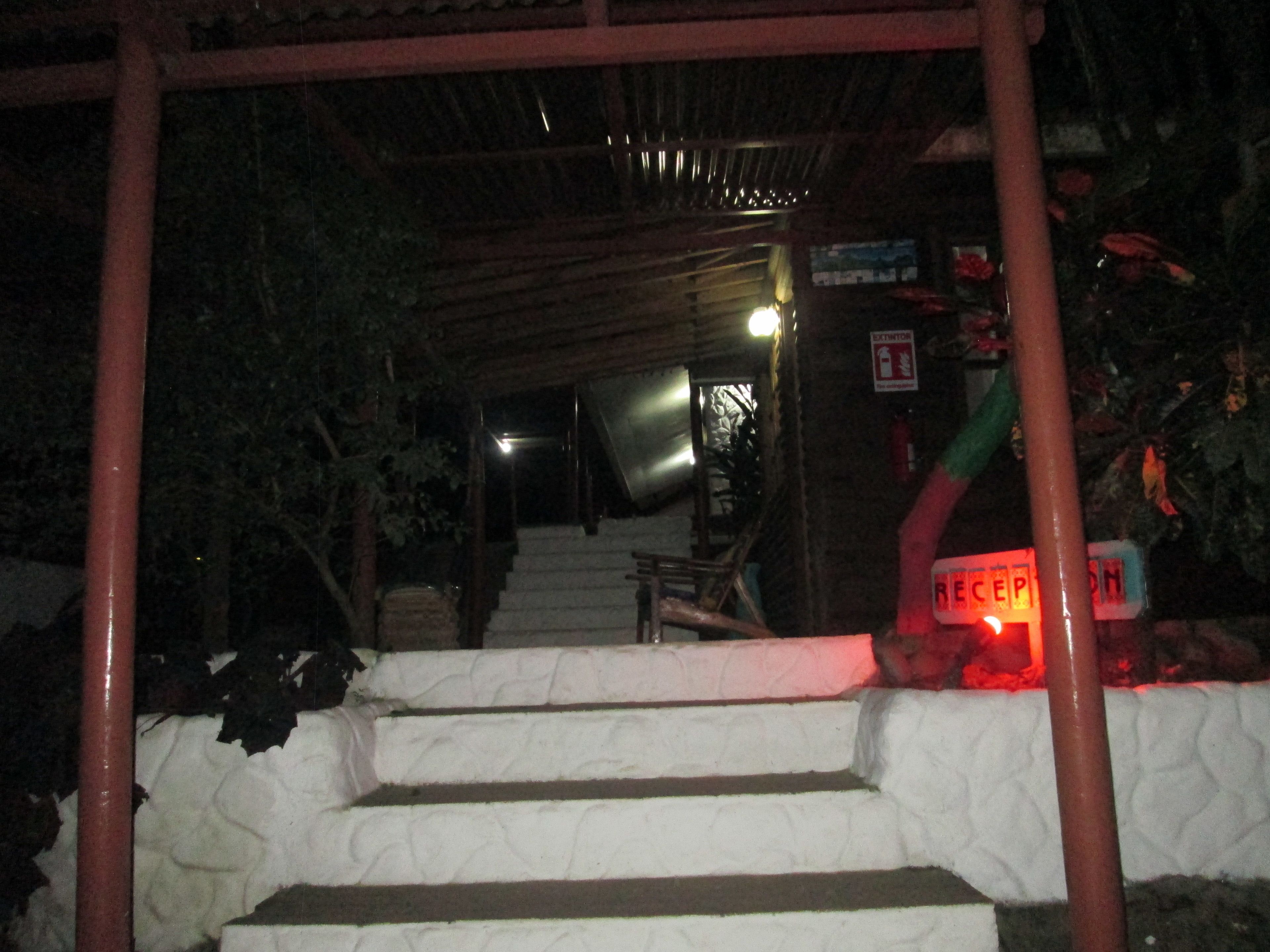 Eine Treppe führt zu einem überdachten Bereich mit einem Empfangsschild.