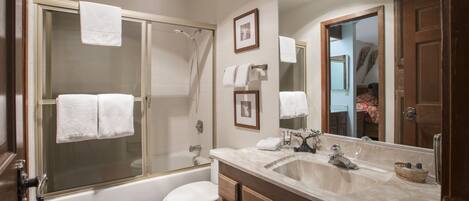 A bathroom with a bathtub, toilet, and sink.