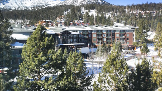 A multi-story hotel with a snow-covered mountain in the background.