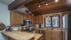 A kitchen with wooden cabinets, stainless steel appliances, and a large window.