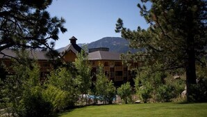 A lodge with a prominent chimney, surrounded by trees and a mountain backdrop. - Sunstone Lodge by 101 Great Escapes (Mammoth Lakes)
