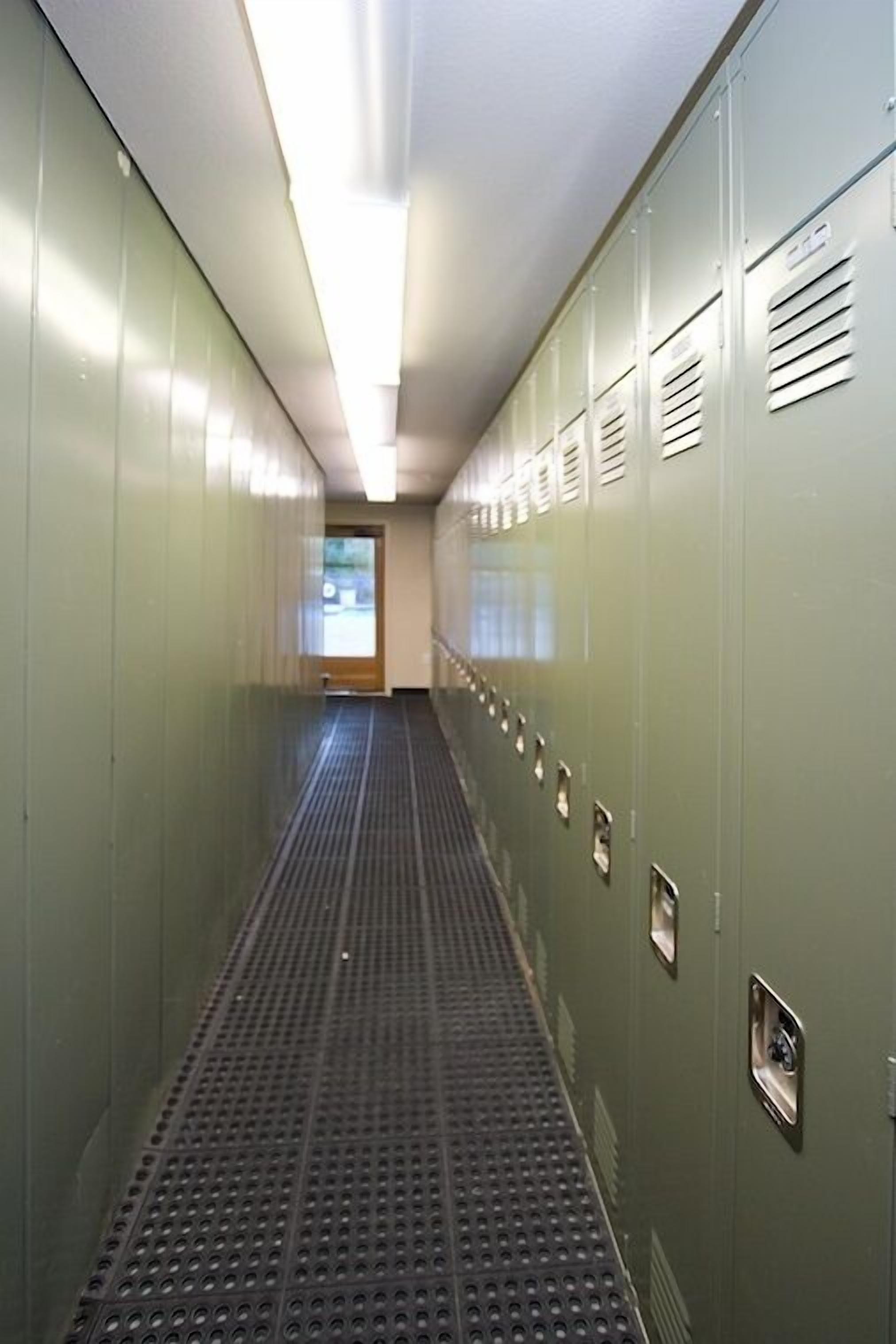 A long hallway with lockers on both sides and a patterned floor.