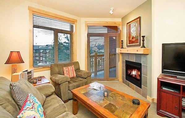 A living room with a fireplace, a television, and a sofa. - Sunstone Lodge by 101 Great Escapes (Mammoth Lakes)