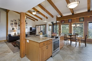 A spacious kitchen with a central island, wooden beams, and large windows. - Timber Ridge Resort by 101 Great Escapes (Mammoth Lakes)