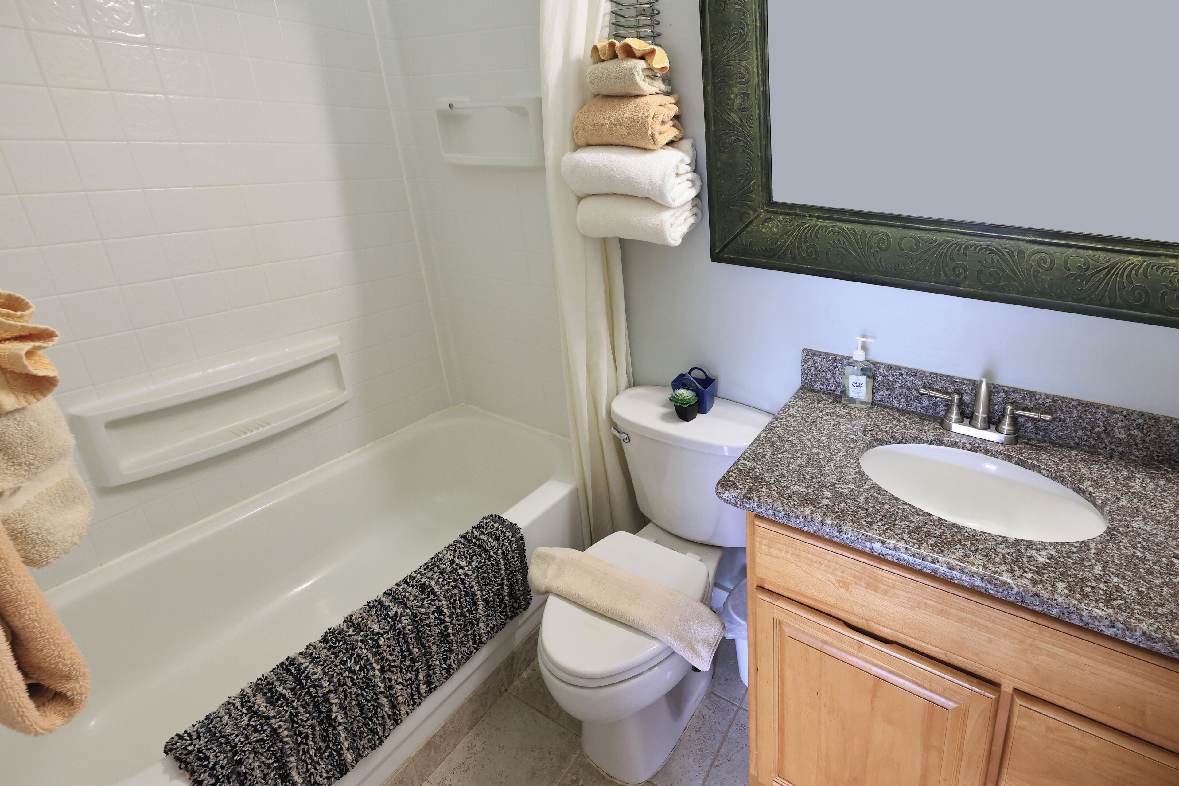 A bathroom with a bathtub, toilet, and sink.