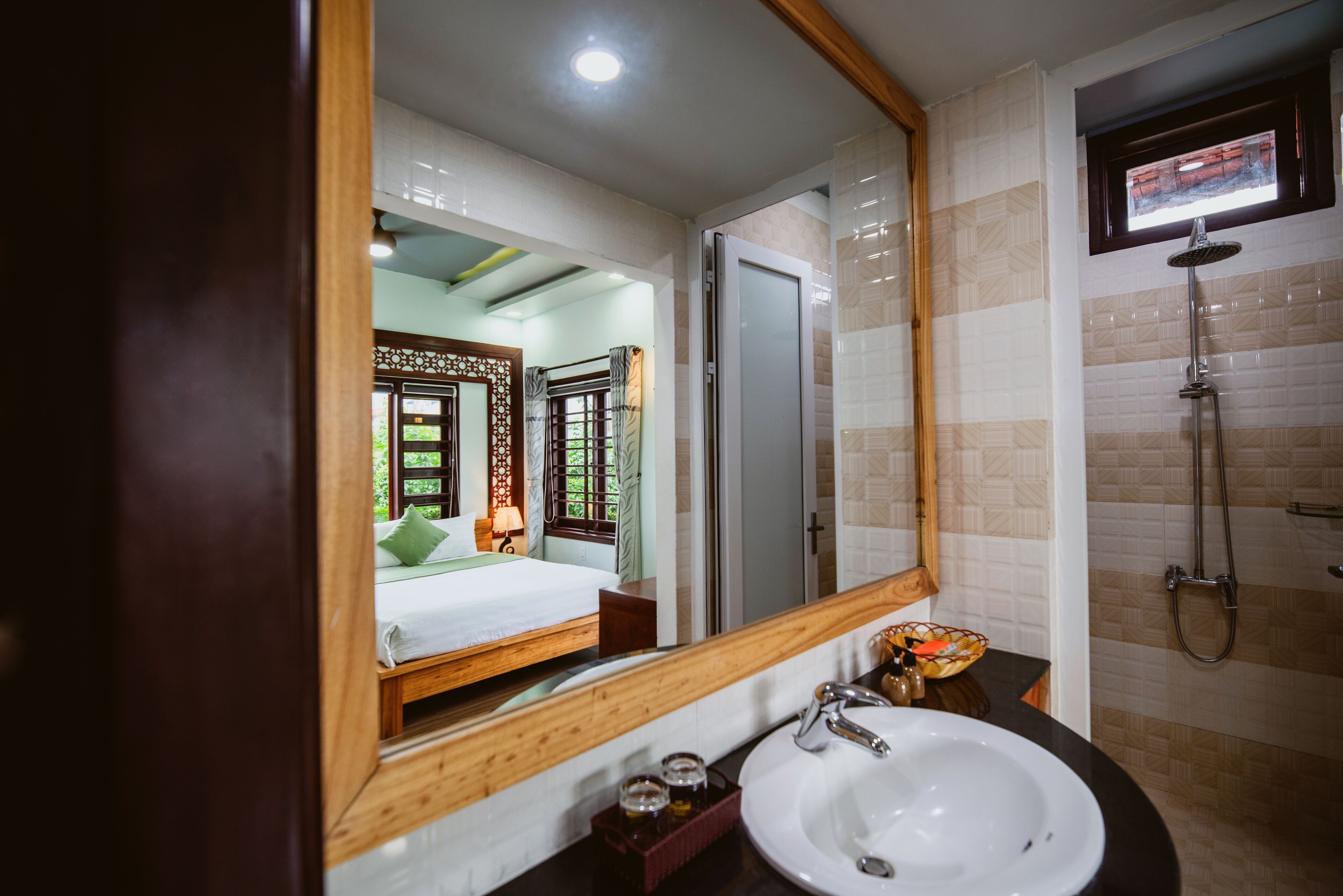 A hotel bathroom with a large mirror, a sink, and a shower.