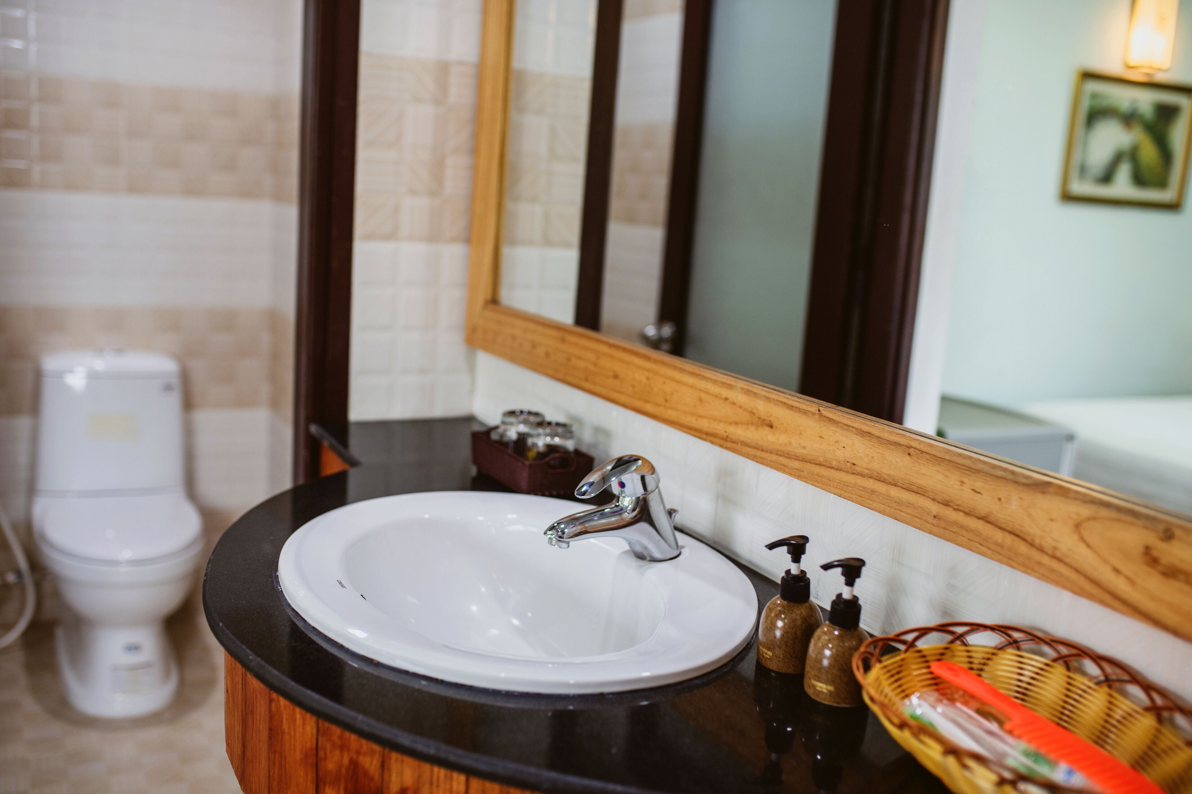 A bathroom with a white sink, a mirror, and a toilet.