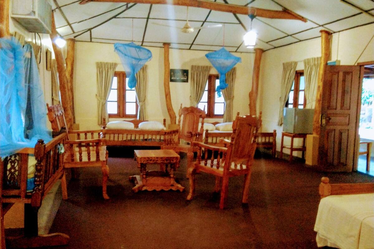 A room with wooden furniture, a ceiling fan, and a window with curtains.