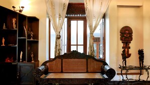 Una habitación tradicional con un sofá de madera, una estantería y un adorno de pared.