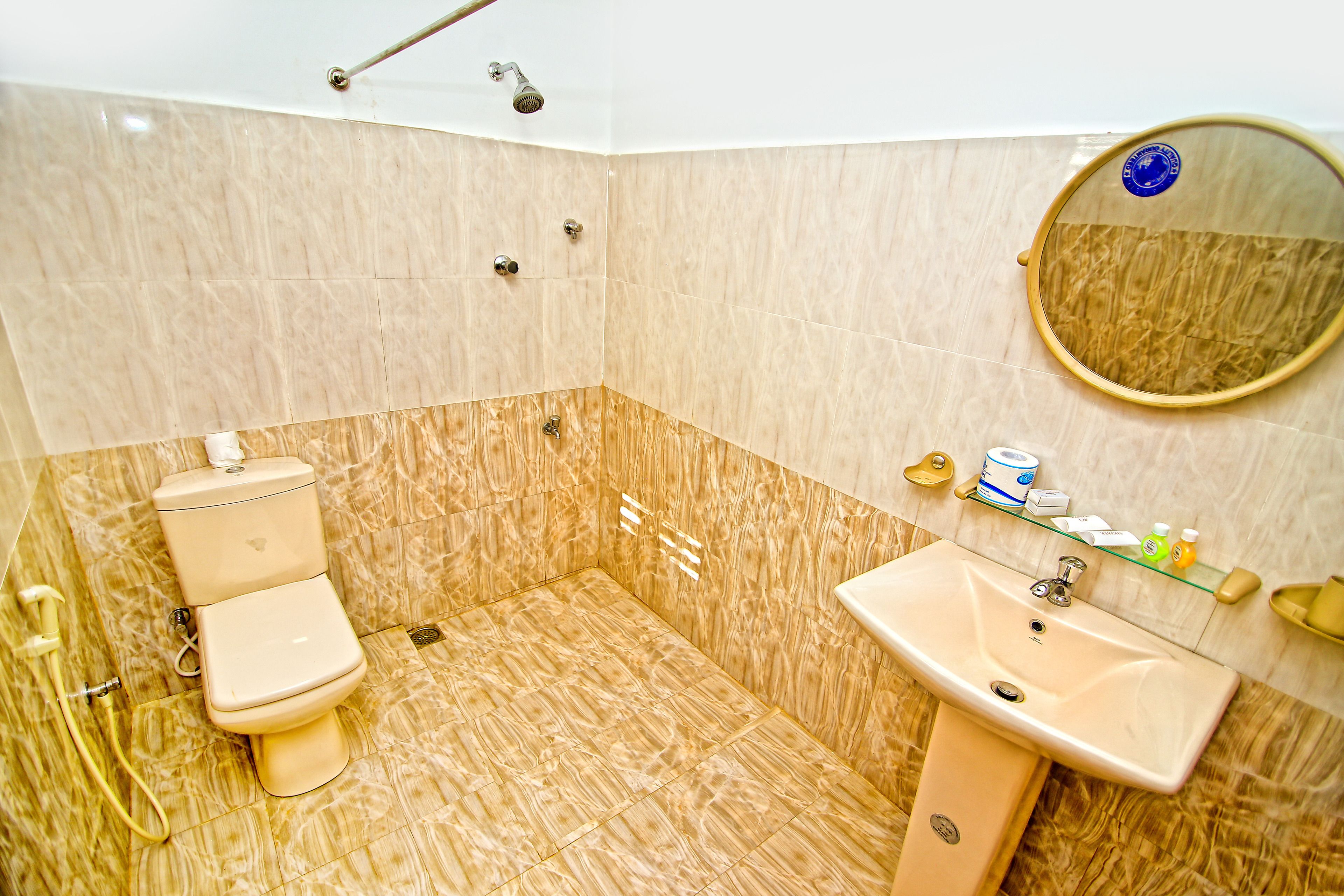 Et badeværelse med toilet, håndvask og brusebad.