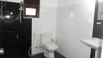Un baño con inodoro, lavamanos y ducha.