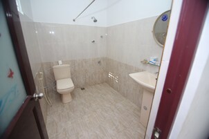 A bathroom with a toilet, sink, and shower.