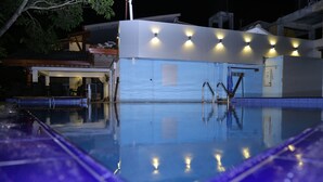 Una piscina con una vista despejada del área de la piscina, incluyendo una sección cubierta con una puerta y una escalera que da a la piscina.