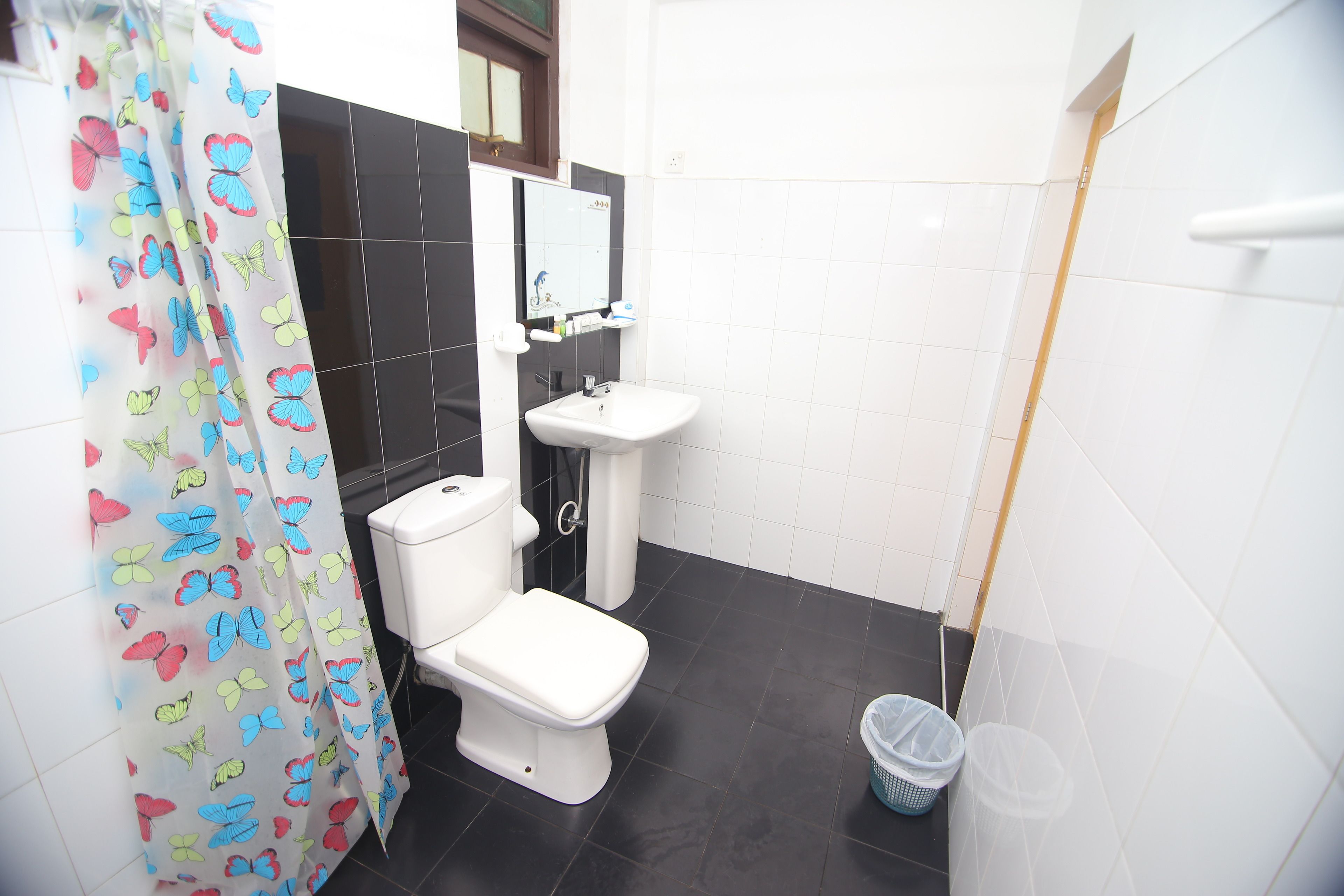 A bathroom with a toilet, sink, and shower curtain.
