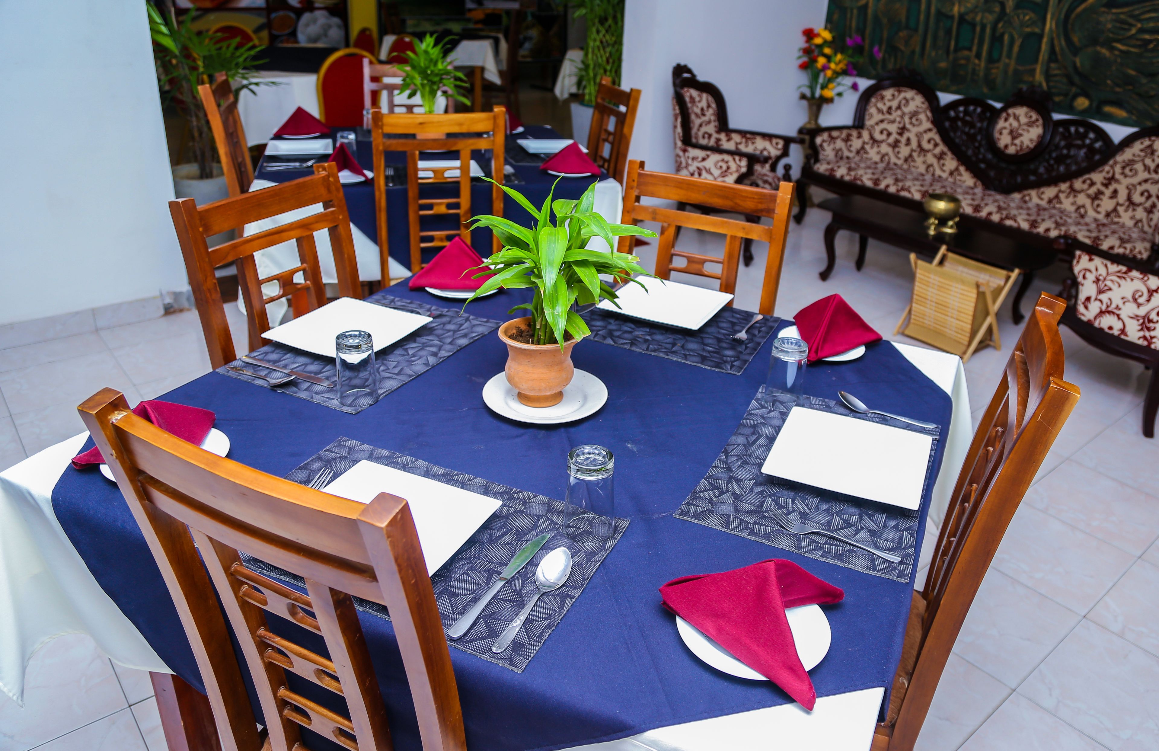 Un comedor con una mesa redonda dispuesta para cuatro personas, rodeada de sillas de madera.