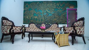 Una habitación con un conjunto de sofás, una mesita con revistas y un cuadro decorativo grande en la pared.