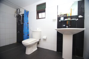A bathroom with a toilet, shower, and sink. - Thilaka City Hotel (Anuradhapura)