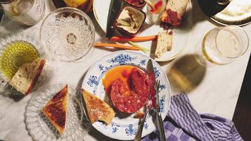 Mesa de jantar com diversos pratos, copos e talheres, indicando uma preparação para refeição.