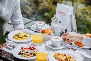 Een ontbijttafel met diverse gerechten, een menukaart en een glas sinaasappelsap.