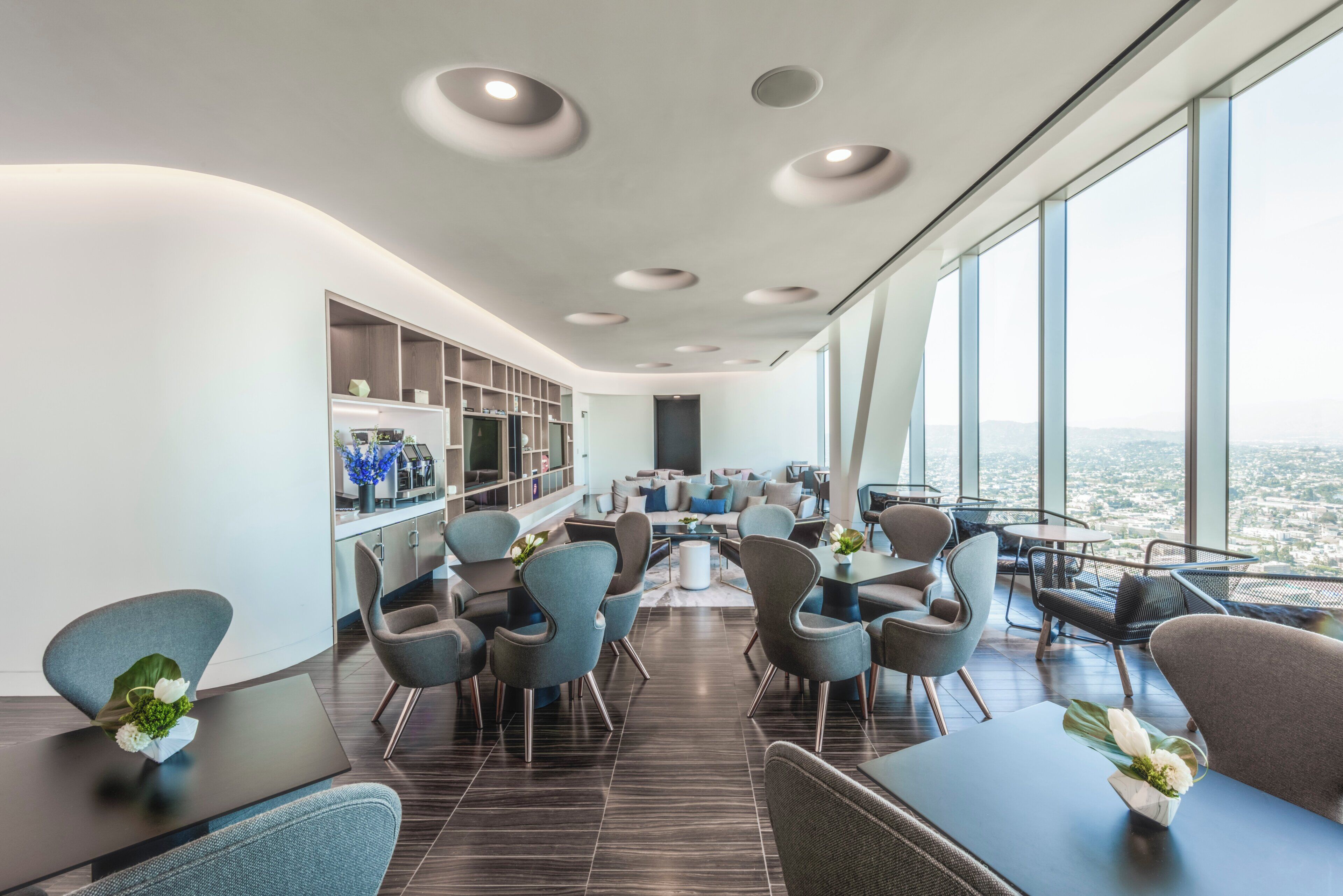 Un interior moderno con comedor, asientos y vistas de la ciudad.