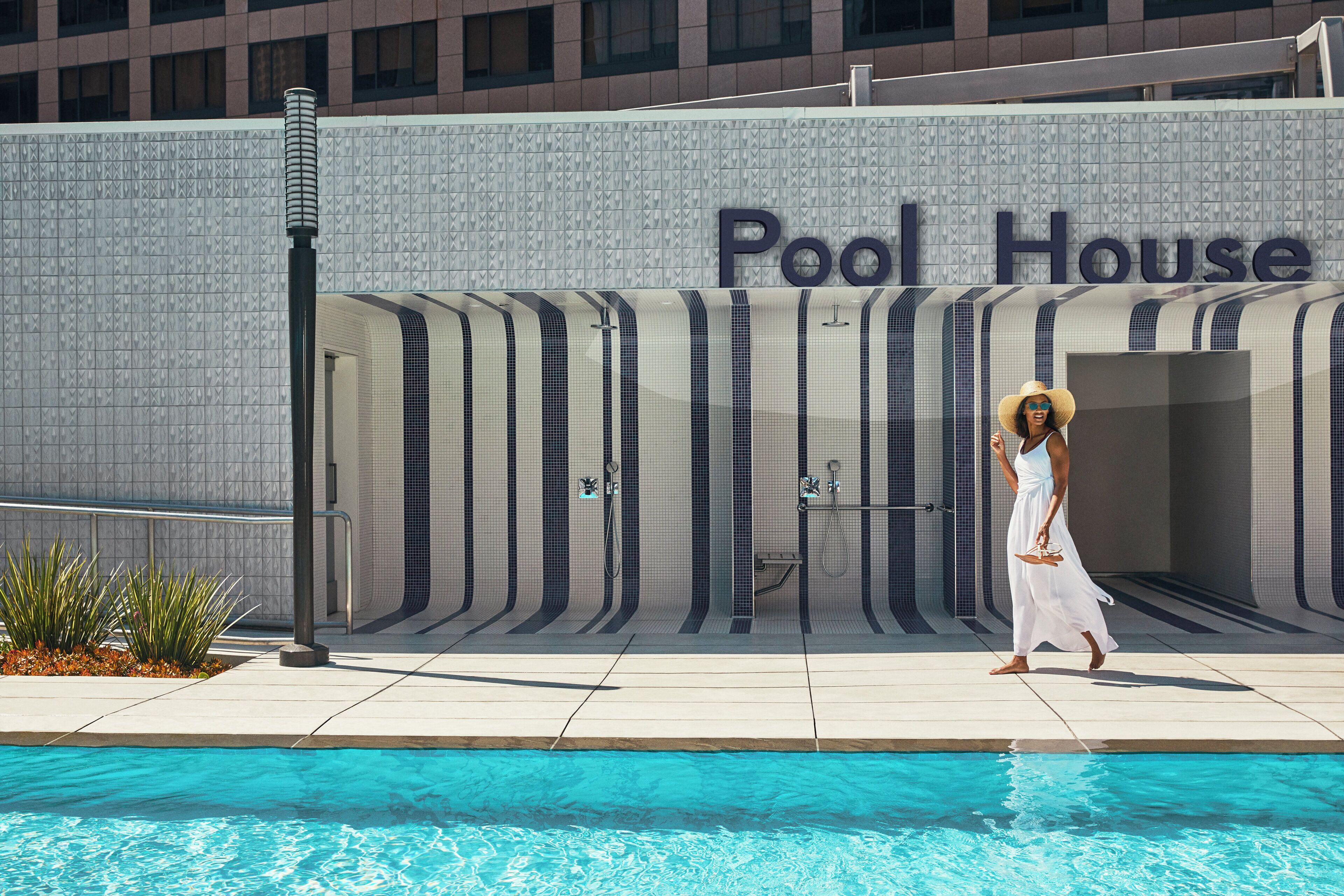 Une zone autour d’une piscine avec un panneau indiquant « Pavillon de la piscine », et une personne qui passe.