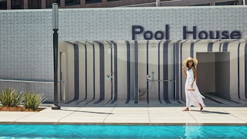 Une zone autour d’une piscine avec un panneau indiquant « Pavillon de la piscine », et une personne qui passe.