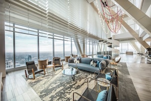 Un espacio habitable amplio con un gran ventanal, muebles modernos y vistas a la ciudad.