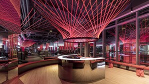 A modern interior with a central circular bar, red lighting, and large windows. - InterContinental Los Angeles Downtown by IHG (Los Angeles)