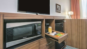 A kitchenette with a West Bend microwave, a coffee maker, and a small refrigerator.