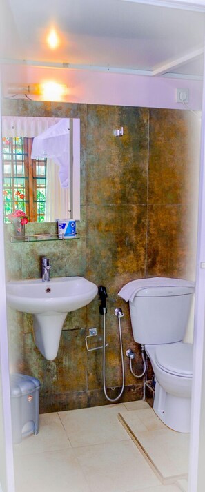 A compact bathroom with a sink, toilet, and shower. - Villu Villa (Anuradhapura)