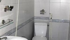 A small bathroom with a toilet, a sink, and a shower. - Phu My Hotel (Da Nang)