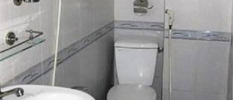 A small bathroom with a toilet, a sink, and a shower.