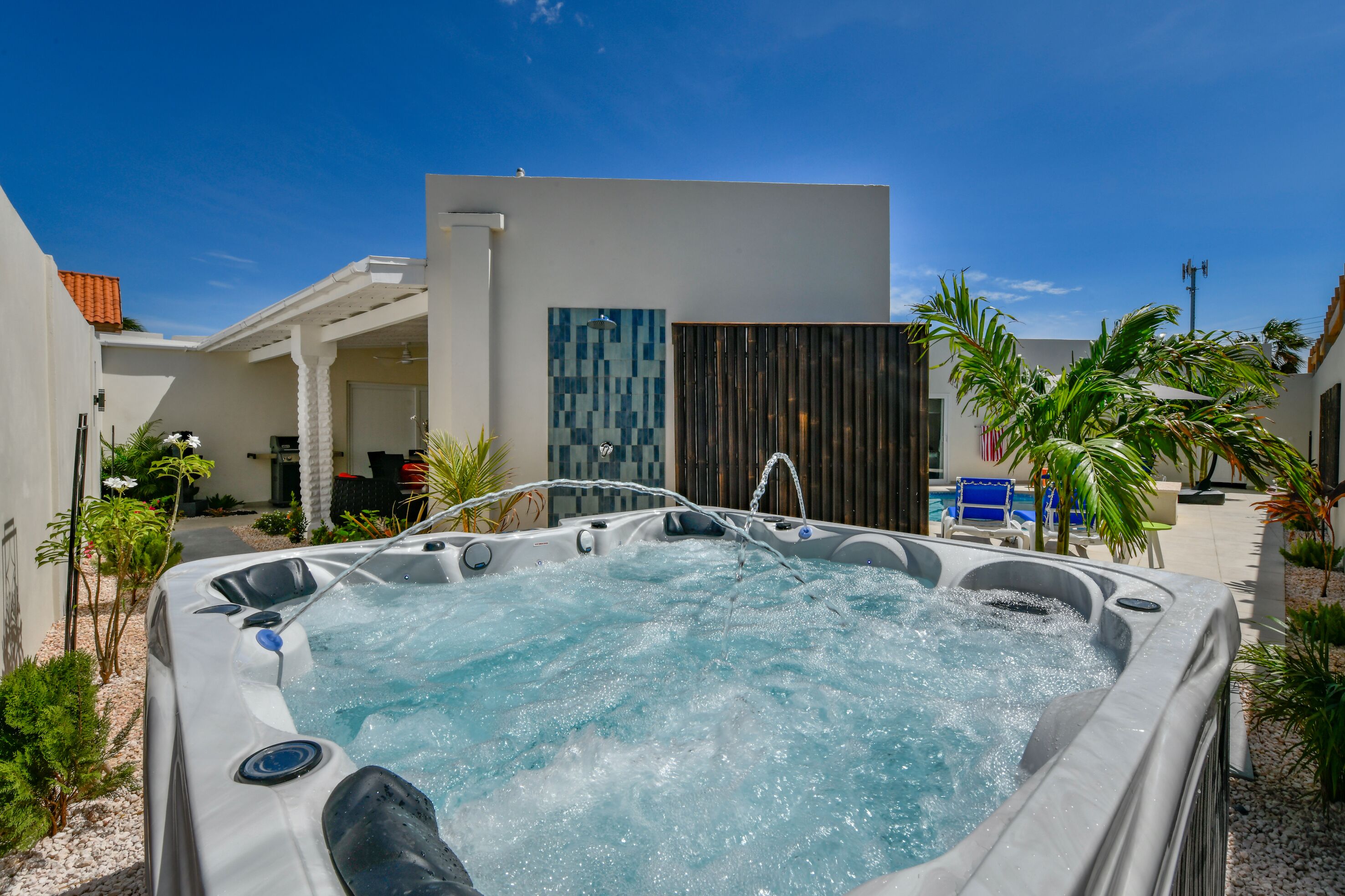 Un jacuzzi en un patio con un edificio moderno al fondo.
