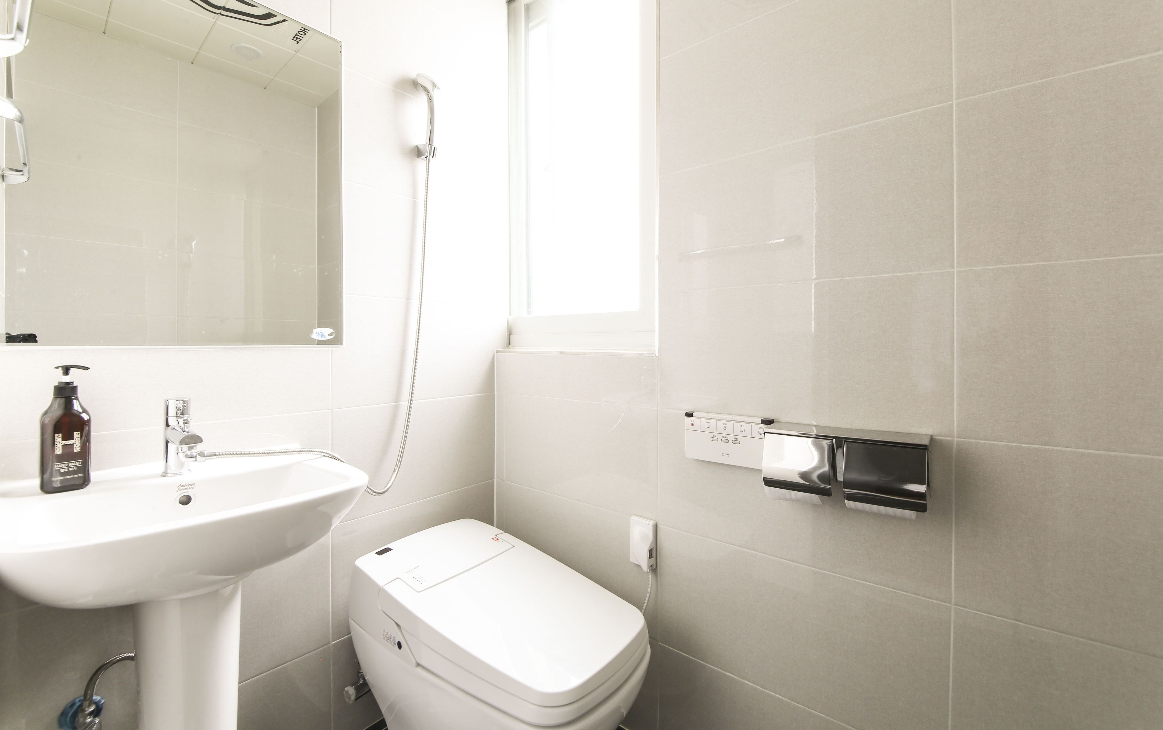 Ein Badezimmer mit Waschbecken, Toilette und Spiegel.