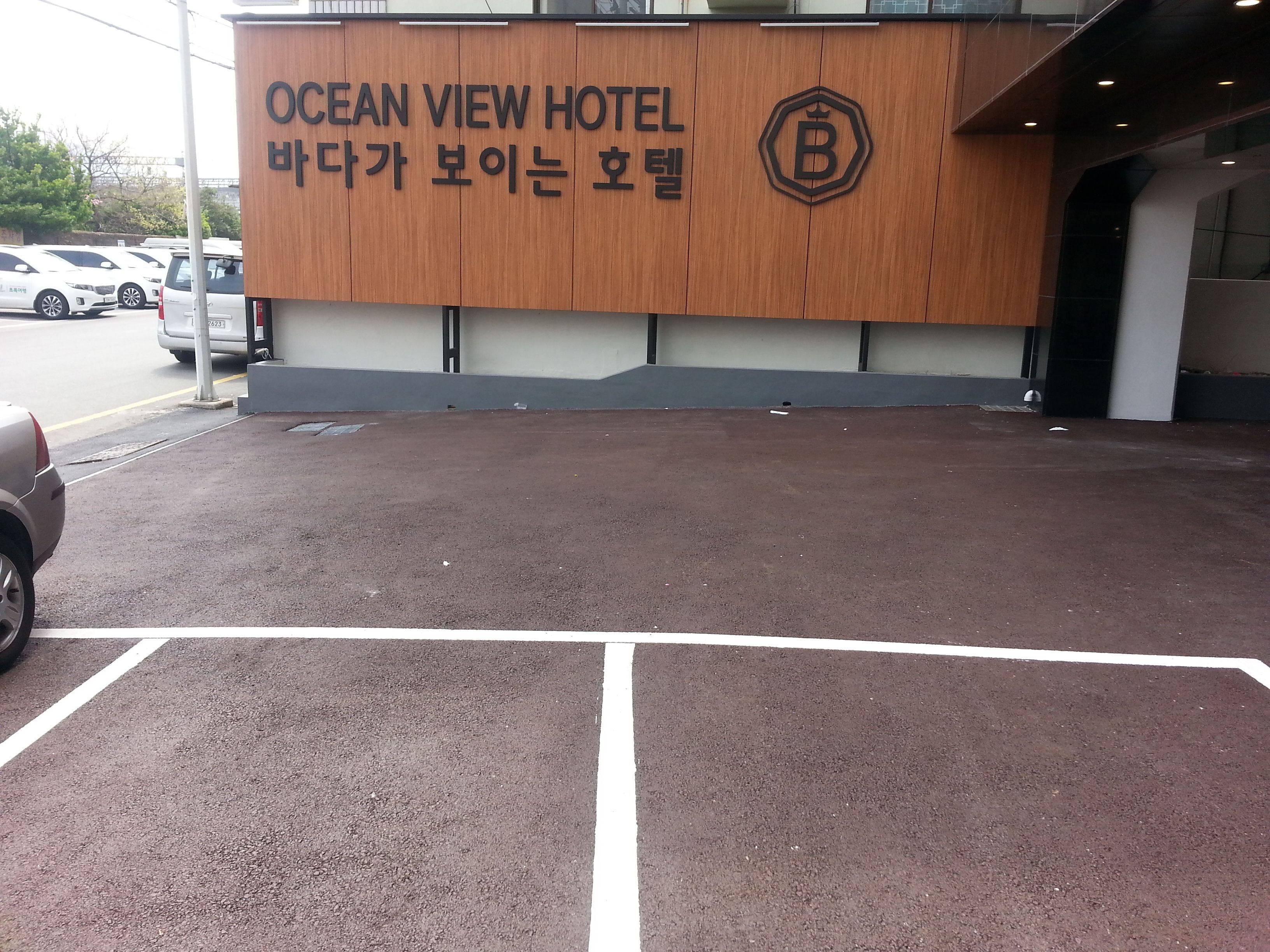 Ocean View Hotels exteriör med en träfasad och en skylt på både engelska och koreanska.