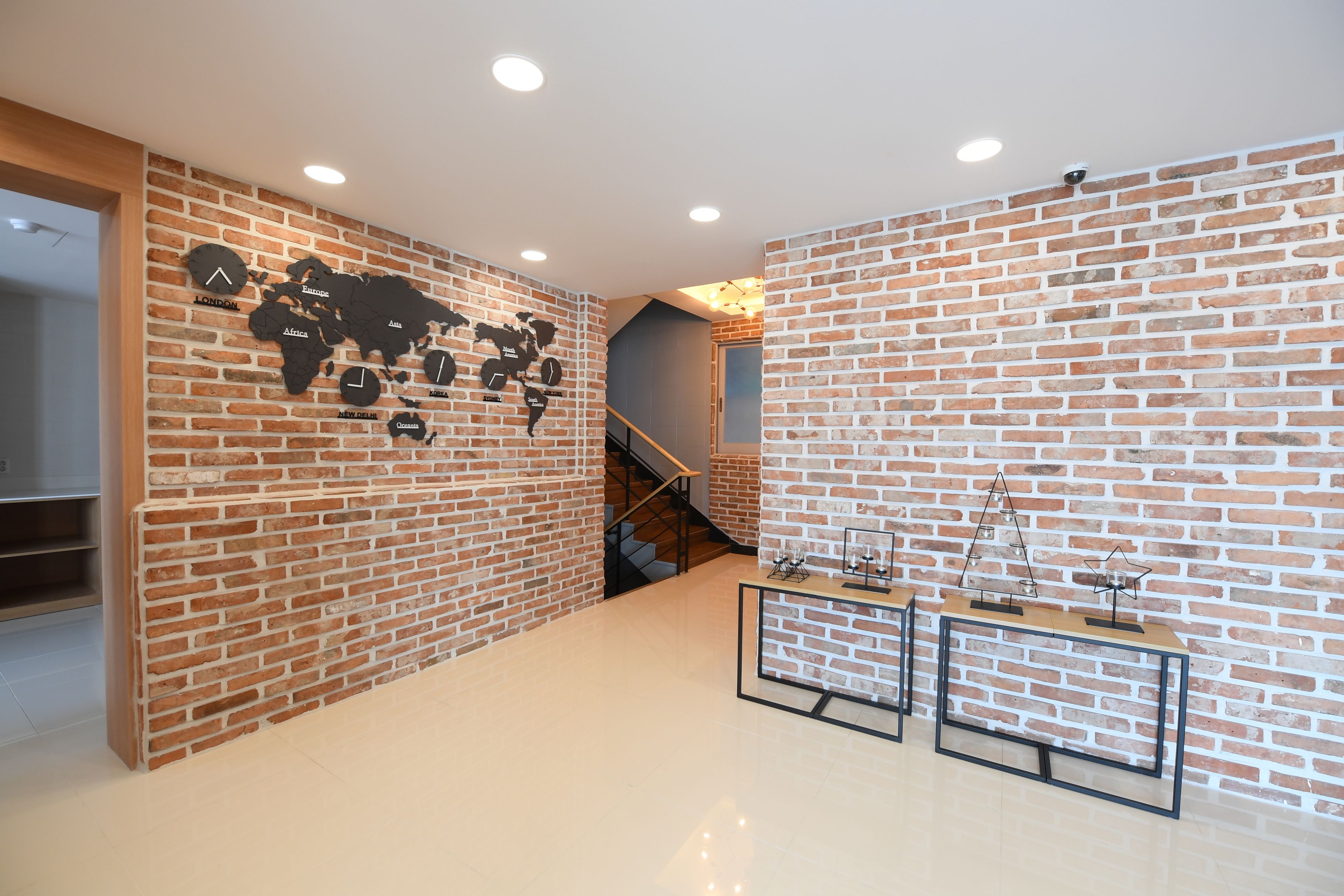 Un interno moderno con pareti in mattoni, una mappa del mondo e una scala.
