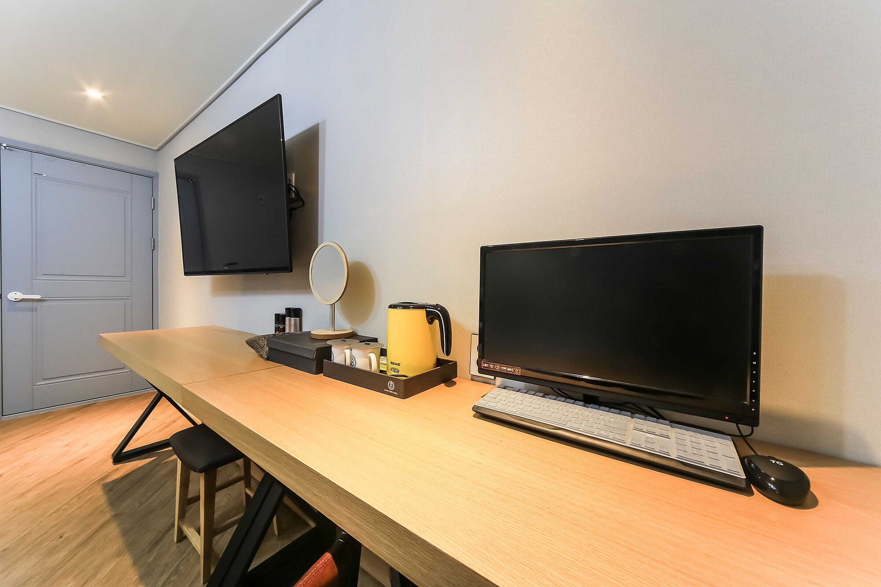 A modern office space with a desk, two monitors, a keyboard, and a mouse.
