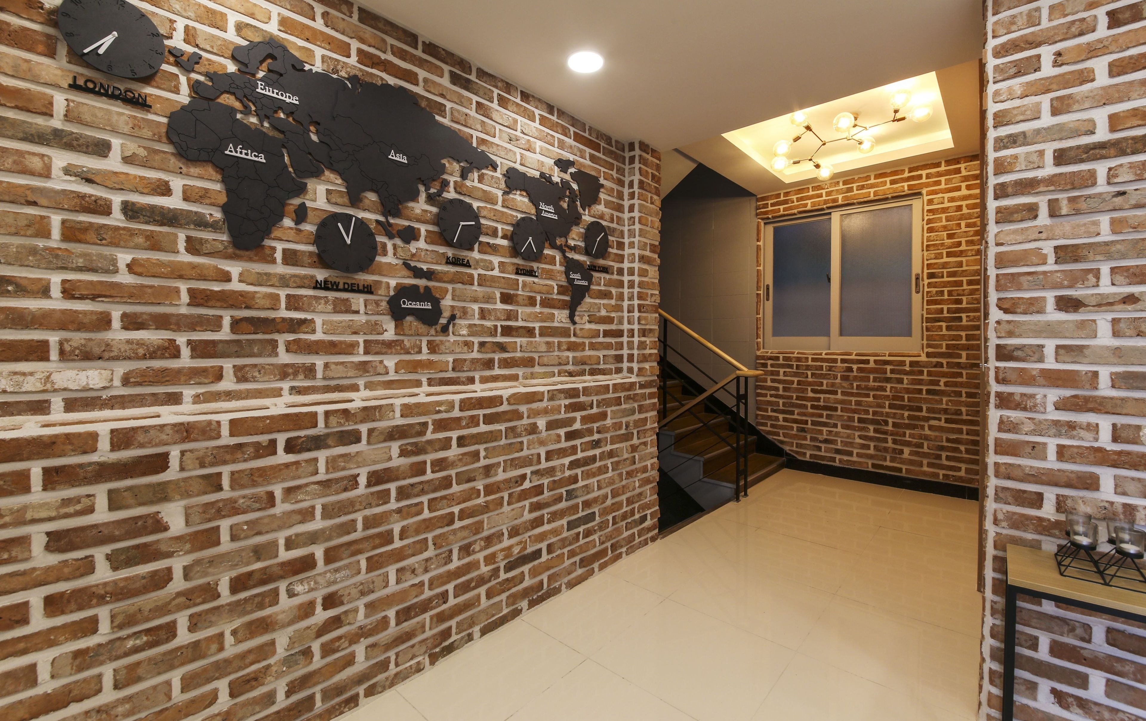 A brick wall with a world map and clocks labeled with city names.