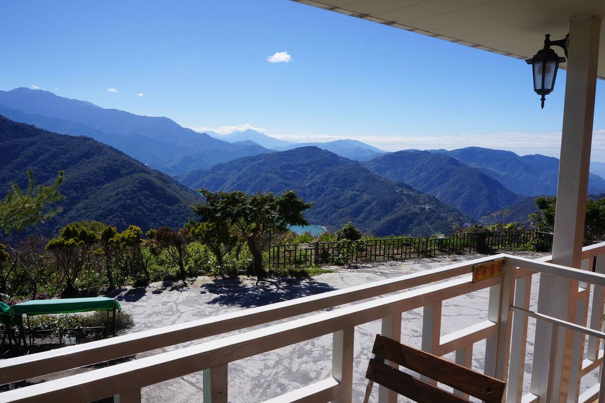Un balcón con vistas a montañas y un lago.