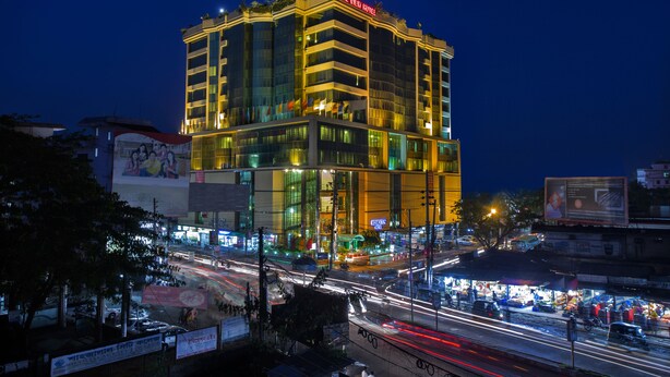 A multi-story hotel with illuminated signage, a prominent entrance, and a busy street below. - Rose View Hotel (Sylhet)