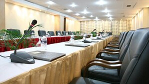 A conference room with a long table, multiple chairs, microphones, and water bottles. - Rose View Hotel (Sylhet)